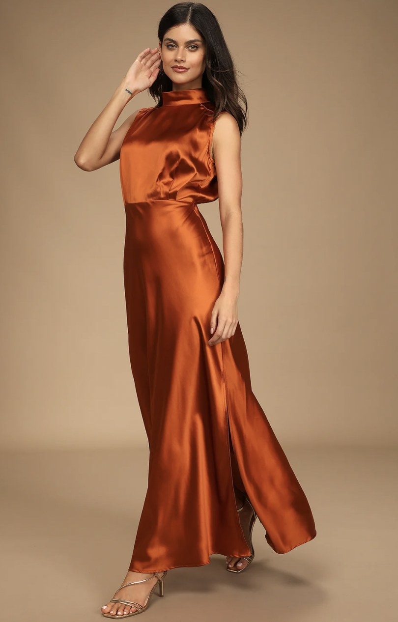 Model strutting in the copper orange maxi dress
