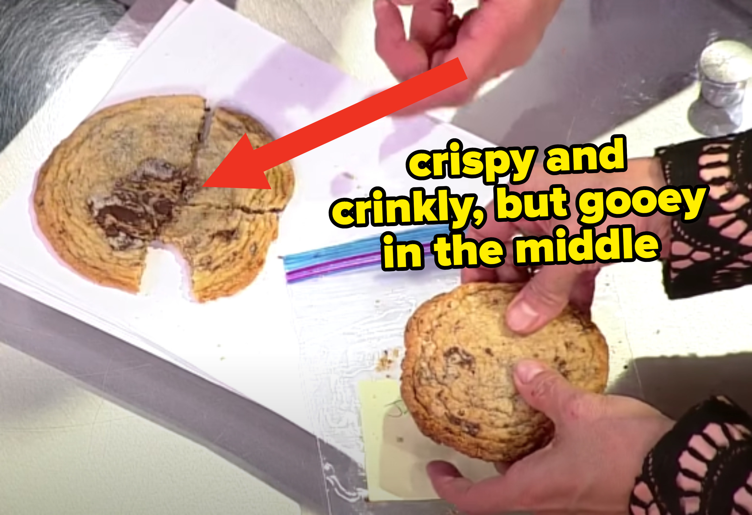 arrow pointing to a large, thin chocolate chip cookie with crinkly edges