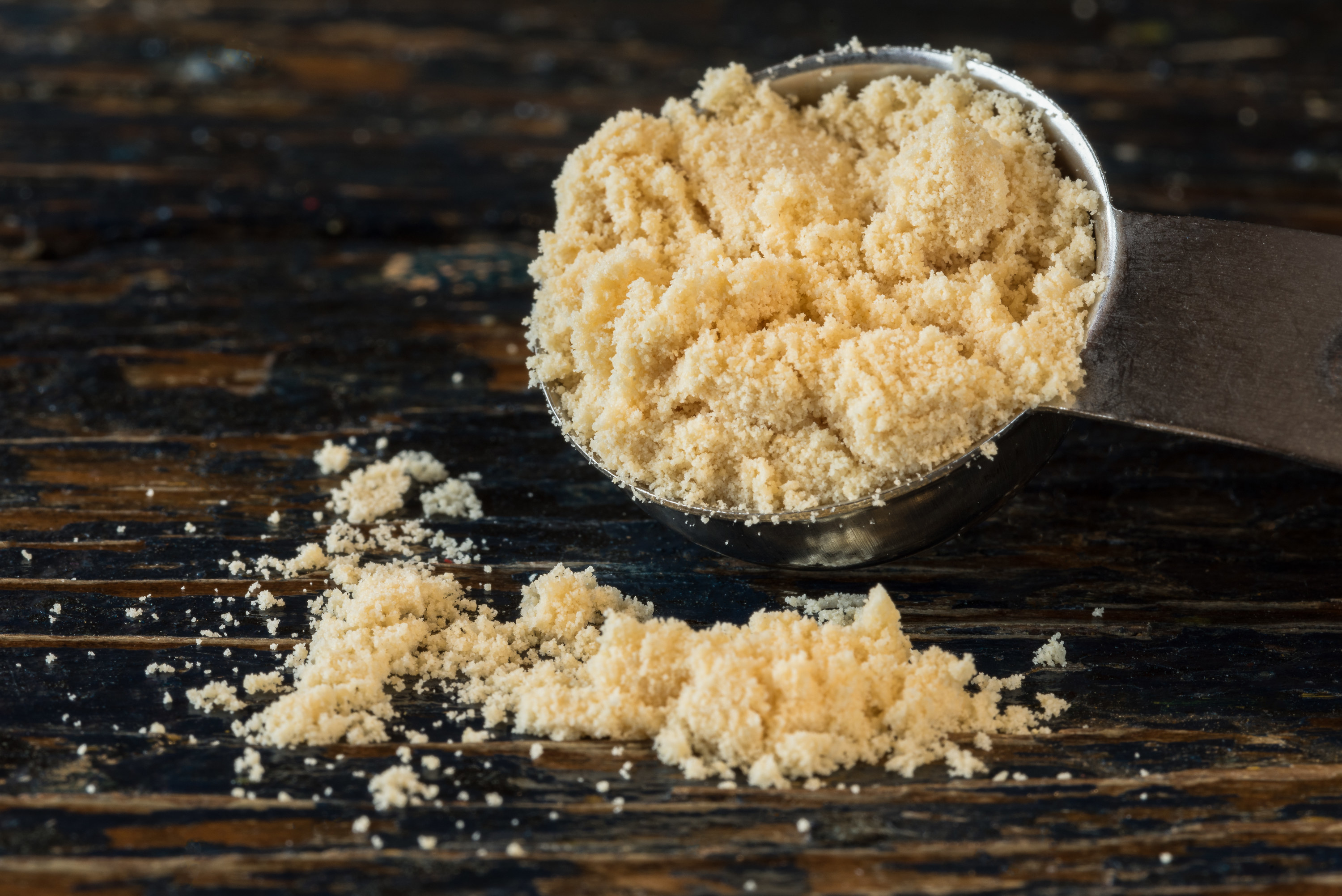 malted milk powder in a measuring spoon