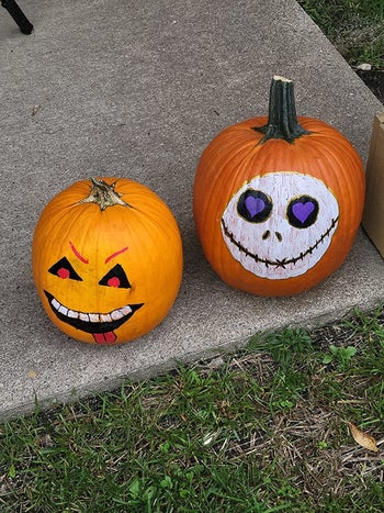 reviewer's photo of two pumpkins decorated with the paint pens
