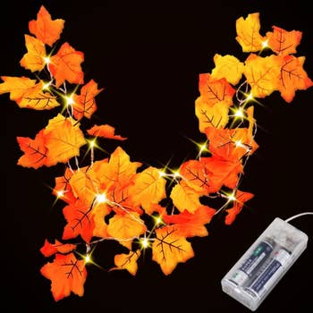 The lit up fall leaves garland  made of yellow and orange artificial leaves