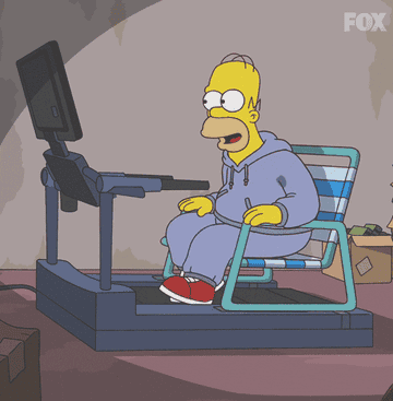 Homer sitting on a lawn chair watching tv on the treadmill