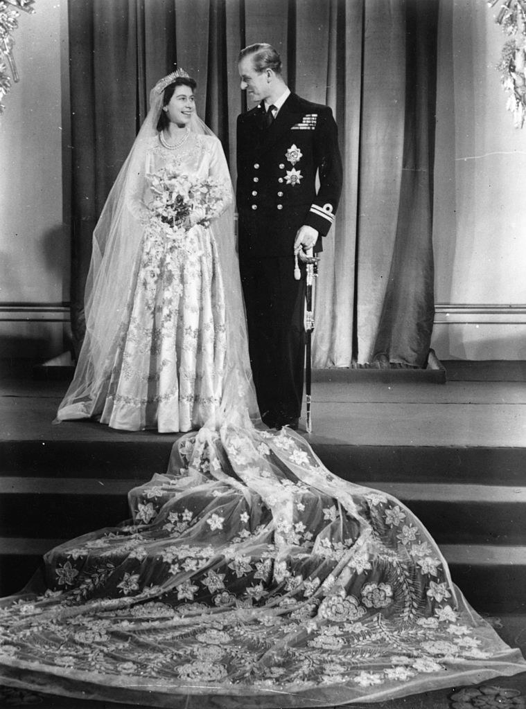 the long veil with flower embellishments trailing on the steps below Queen Elizabeth II