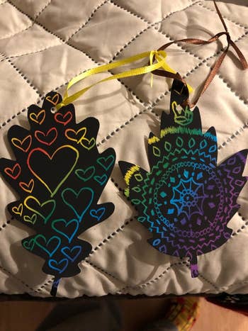 reviewer's photo of rainbow art doodled on black leaves