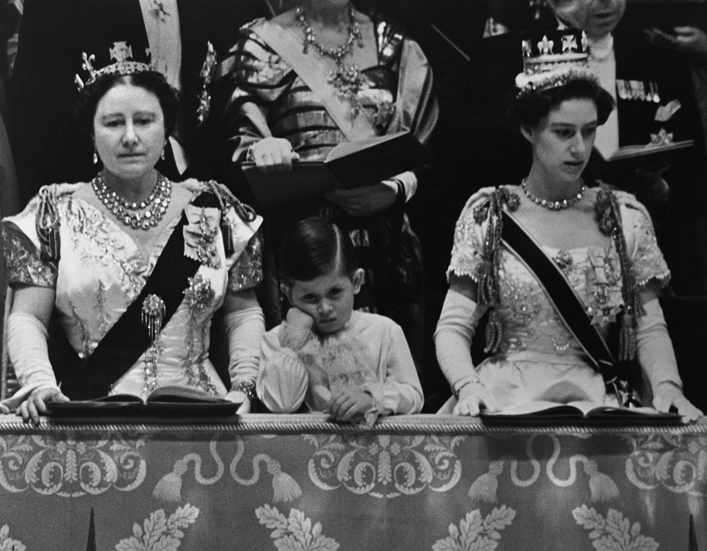 the Queen Mother and Princess Margaret looking down and Prince Charles looking bored