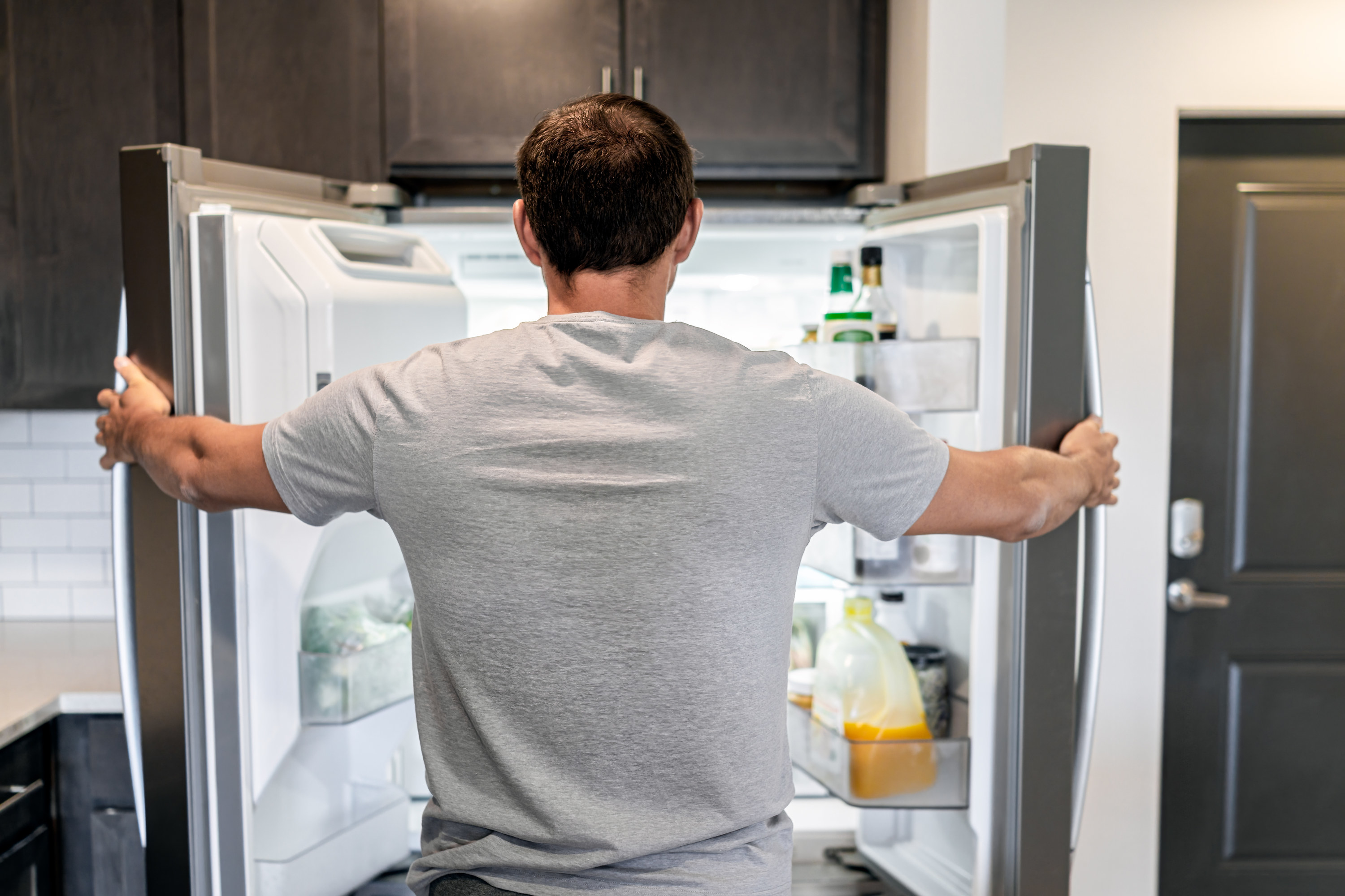 Person standing in front of an open fridge