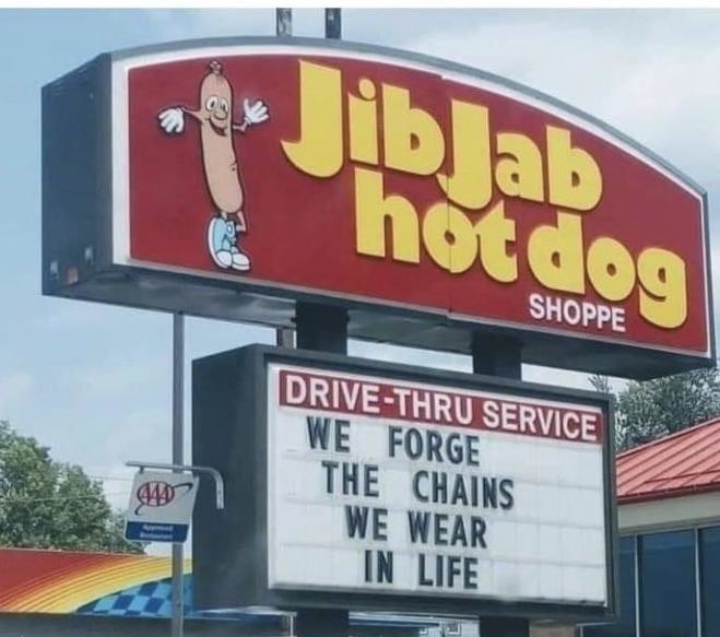 hot dog sign reading we forge the chains we wear in life