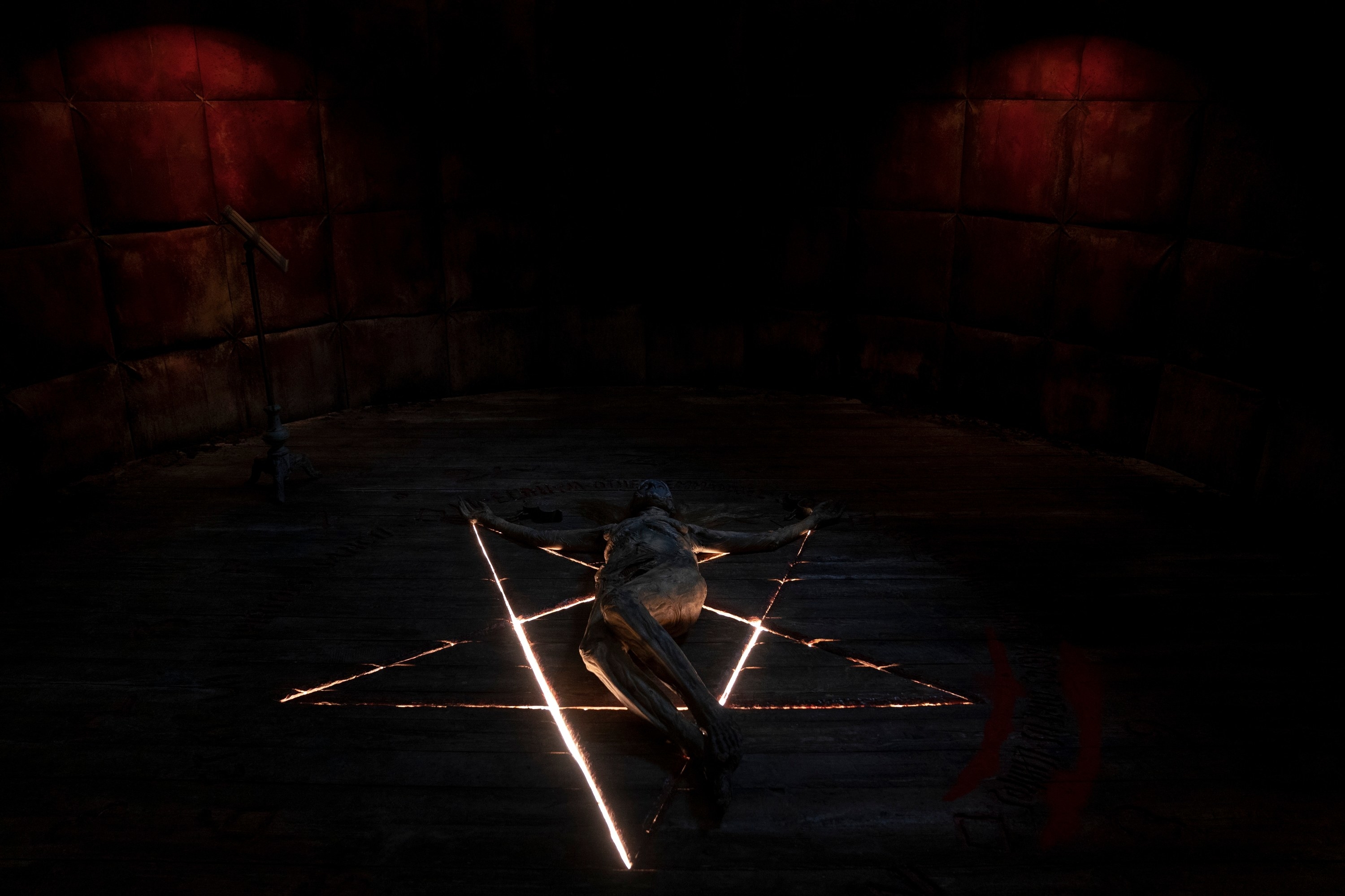 A naked body lays on a pentacle