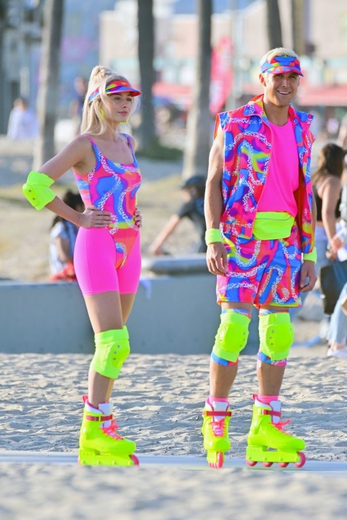 Margot and Ryan Gosling on the beach dressed as Barbie and Ken on roller skates