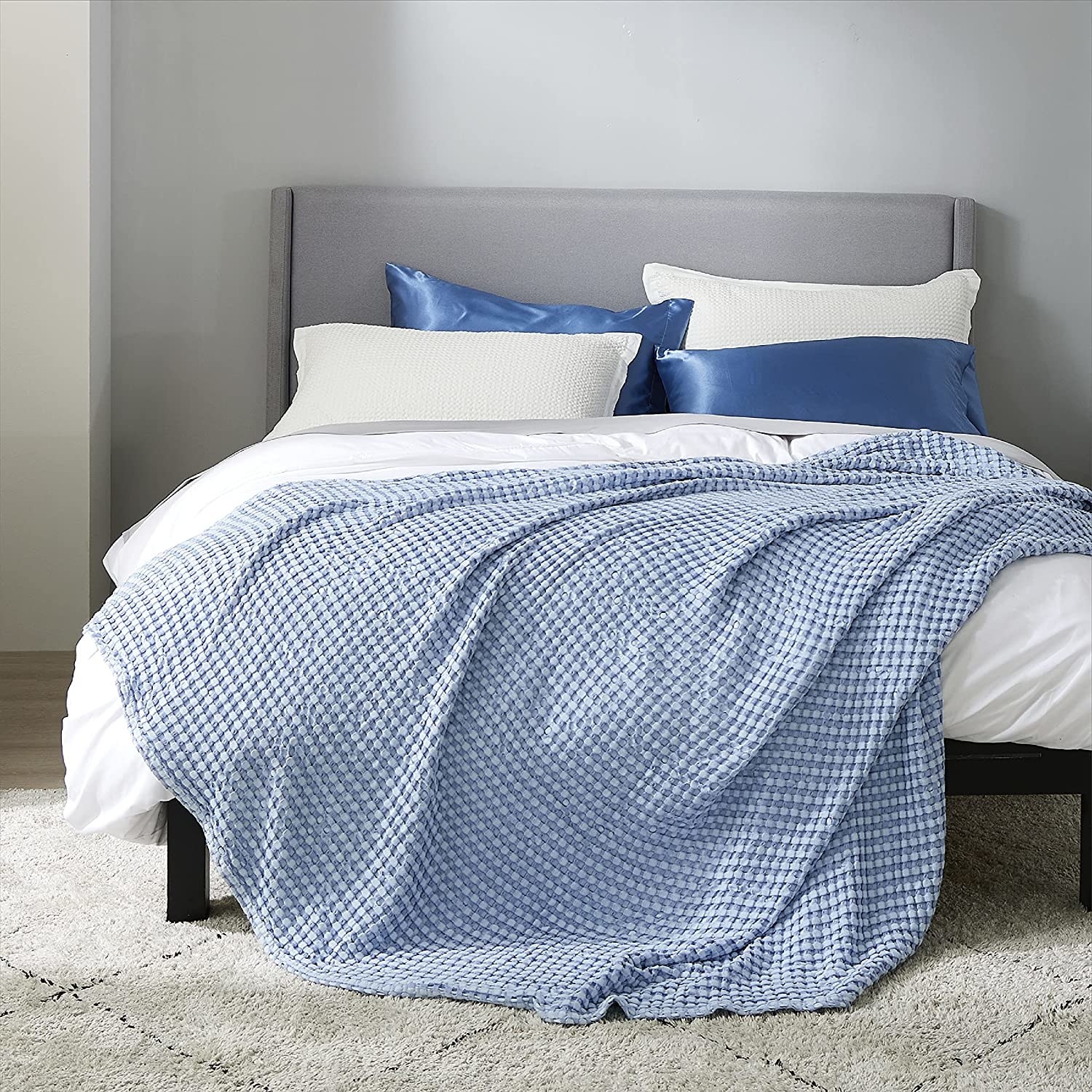 blue waffle cotton blanket over white bedding set