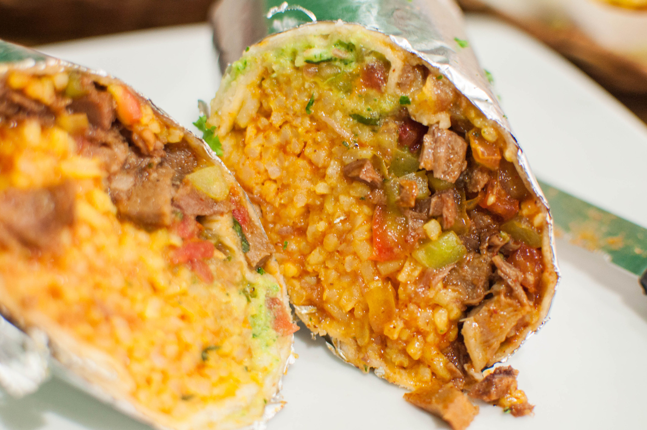 A burrito with rice and meat.