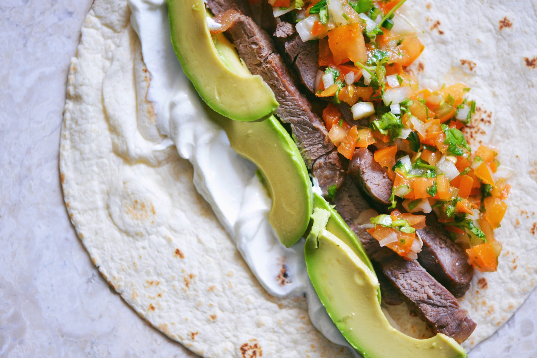 Steak tacos with pico de gallo and avocado.