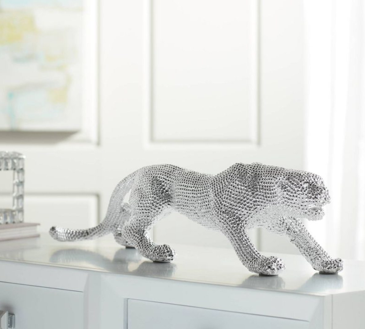 the silver leopard statue on a dresser