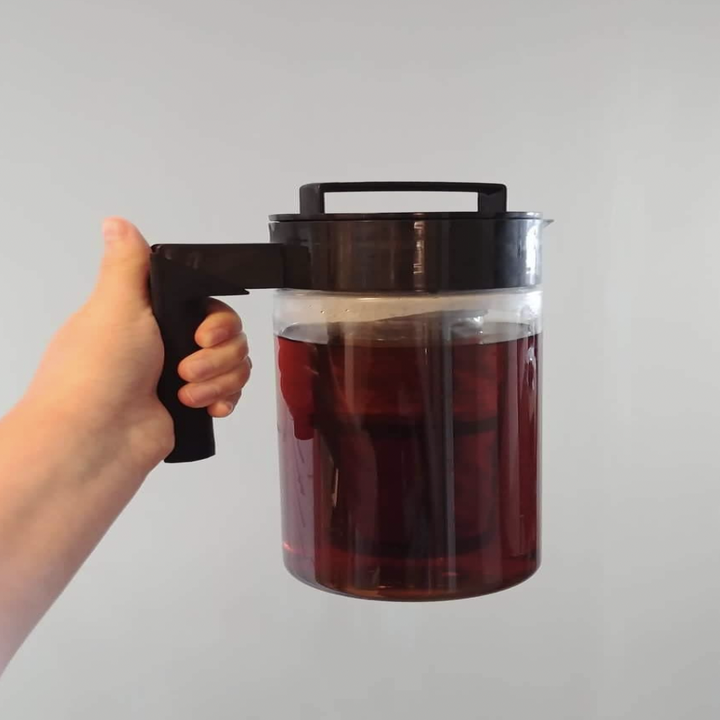 a reviewer holding up their cold brew coffee maker