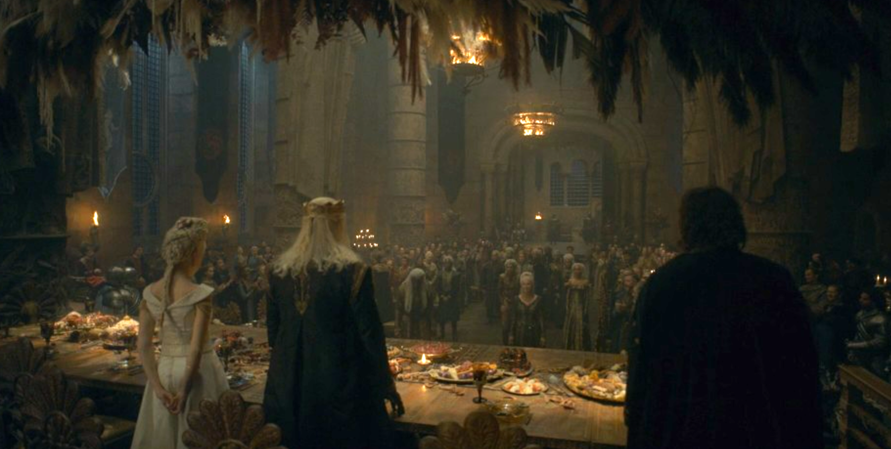 The Great Hall filled with guests, Rhaenyra and Viserys sitting at the head table greeting the Velaryons.
