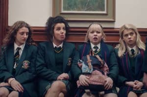 The Derry Girls sitting on a bench at school