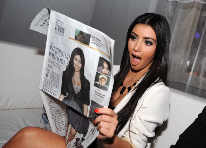 Kim Kardashian holding a newspaper