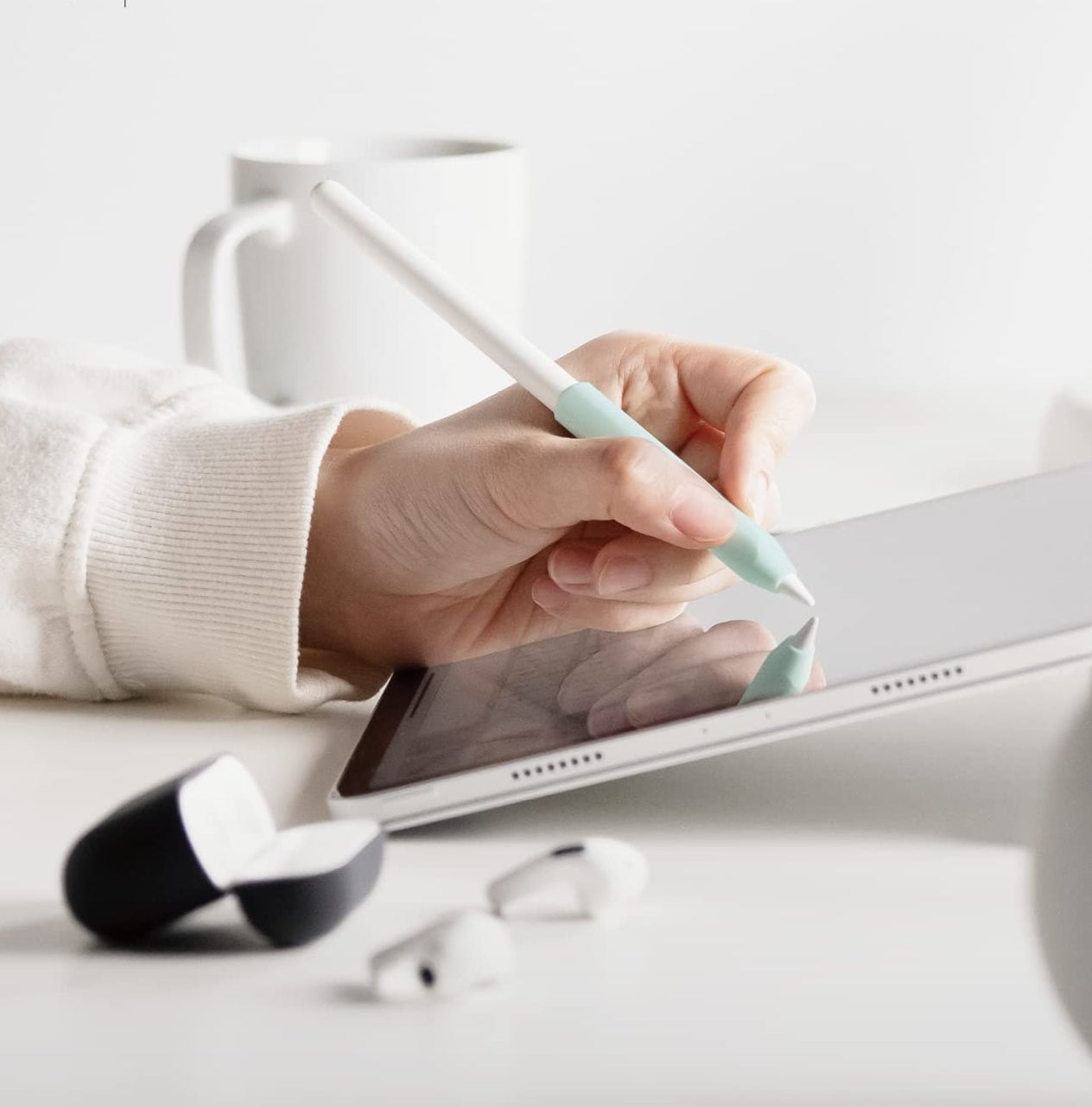 A person using their Apple Pencil with a grip on it