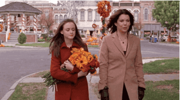 Lorelei and Rory from the Gilmore Girls walking around with a fall background