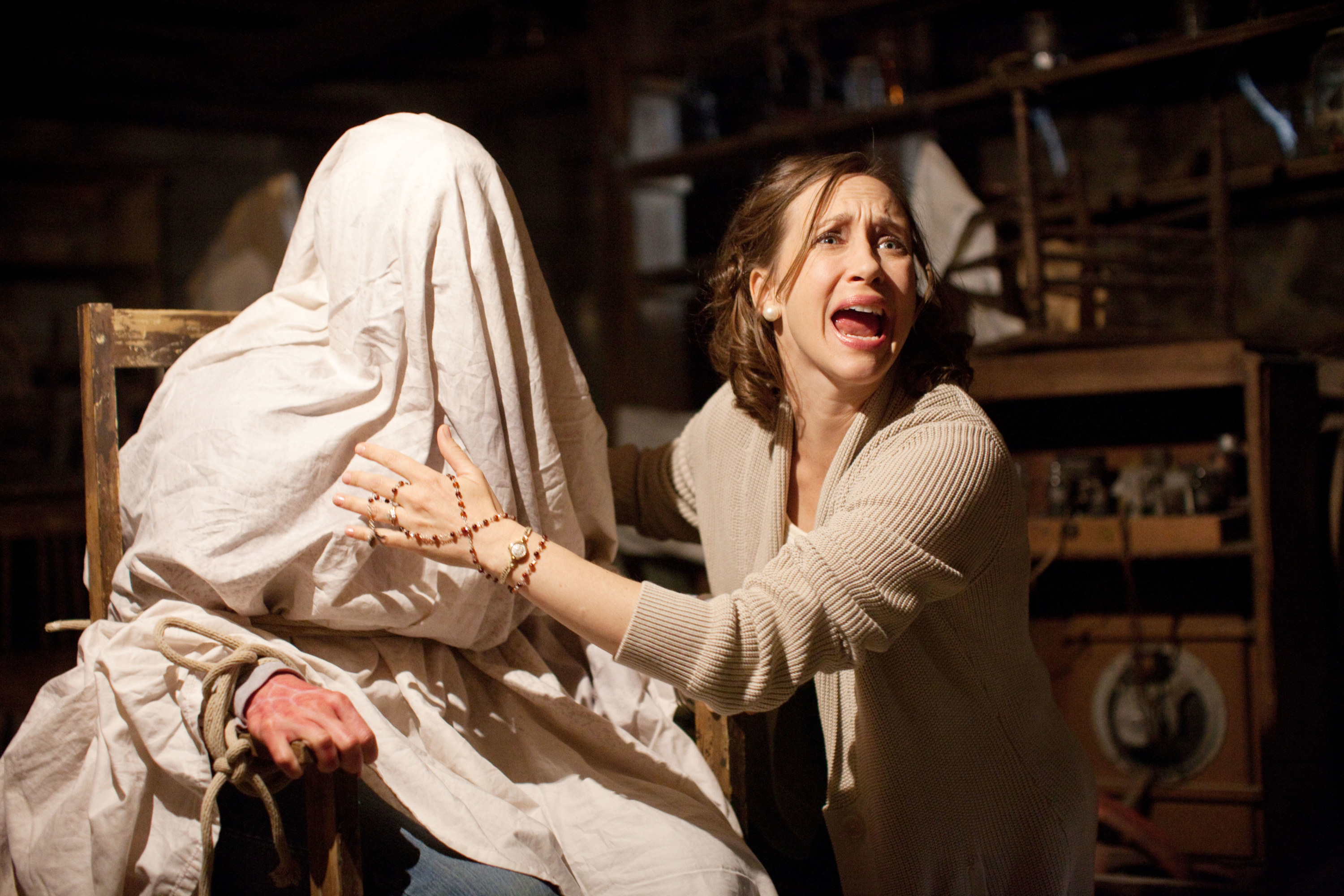 Vera Farmiga shouts next to someone with a sheet over their head