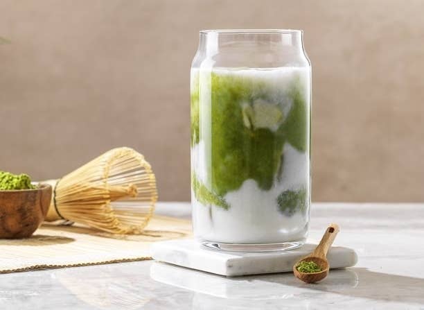 the glass with matcha and cream in it