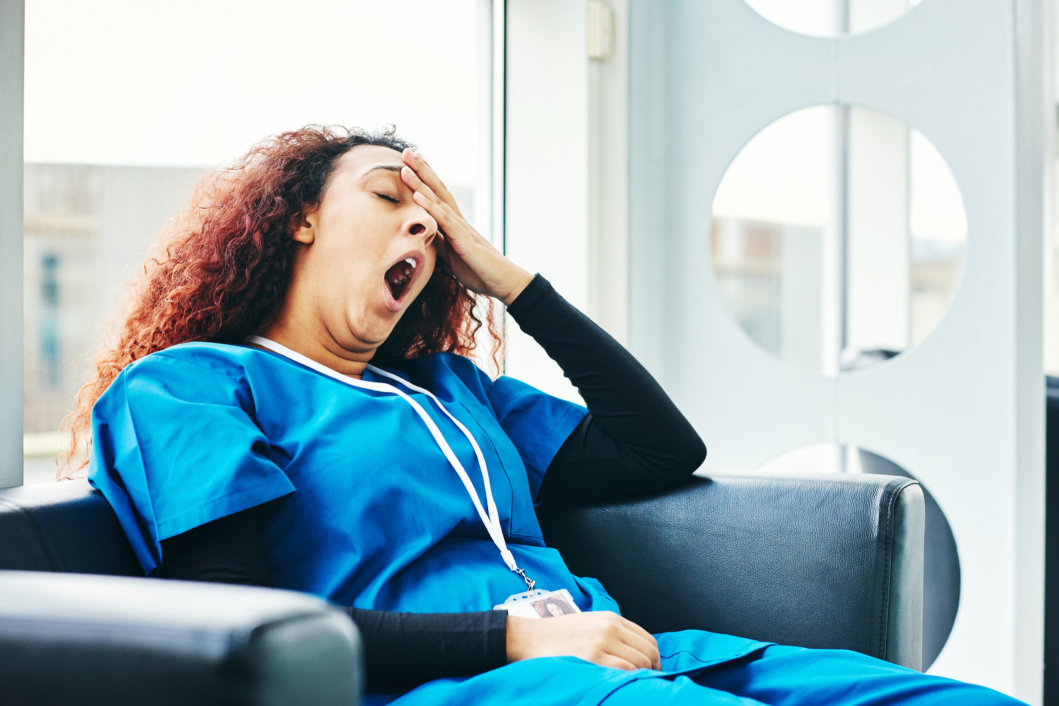 An exhausted nurse yawning