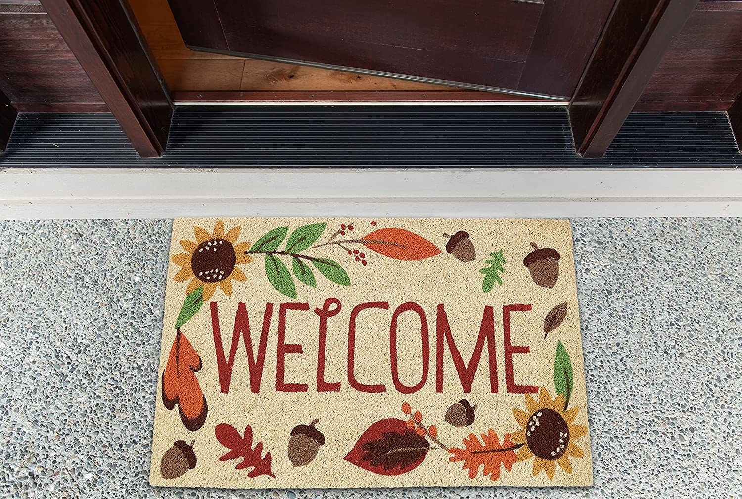 the mat that says welcome with leaves and acorns in front of a door