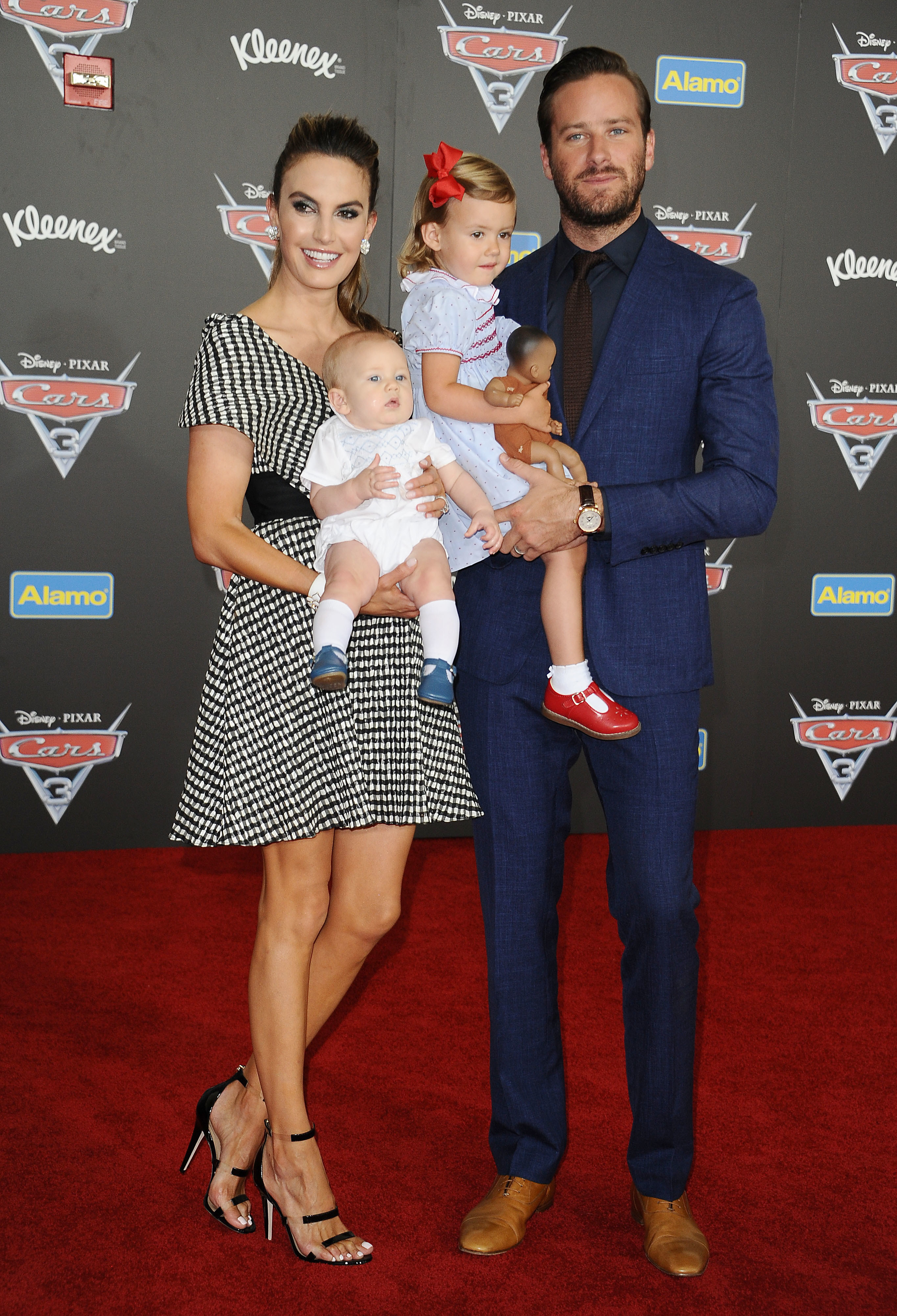 Elizabeth and Armie holding their children on the red carpet