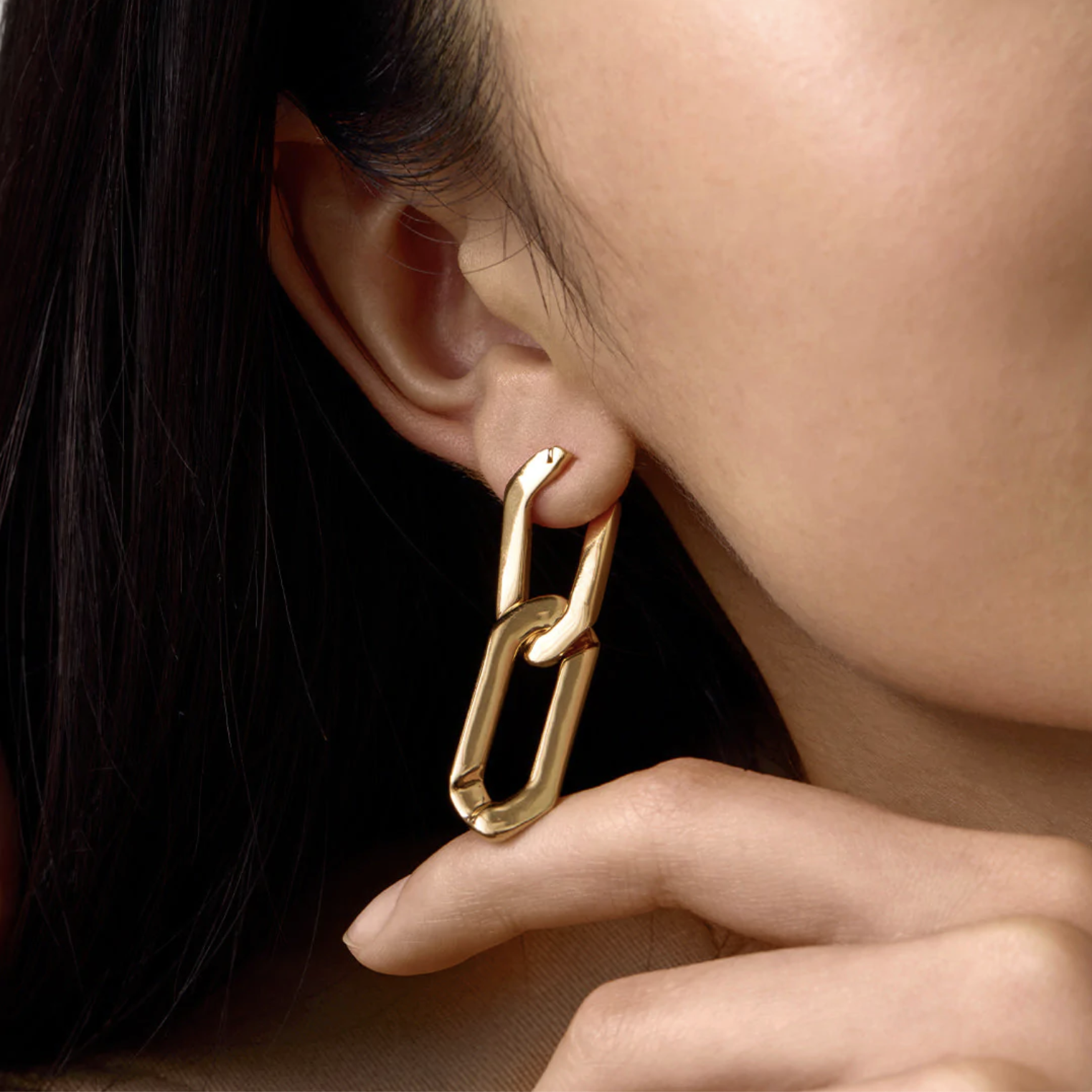 A person wearing a link earring in their lobe