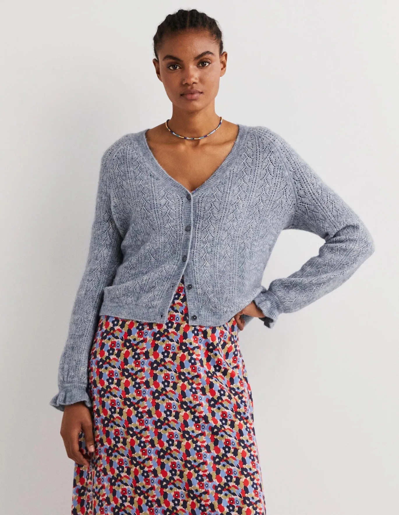 model wearing cropped gray cardigan with floral-print skirt