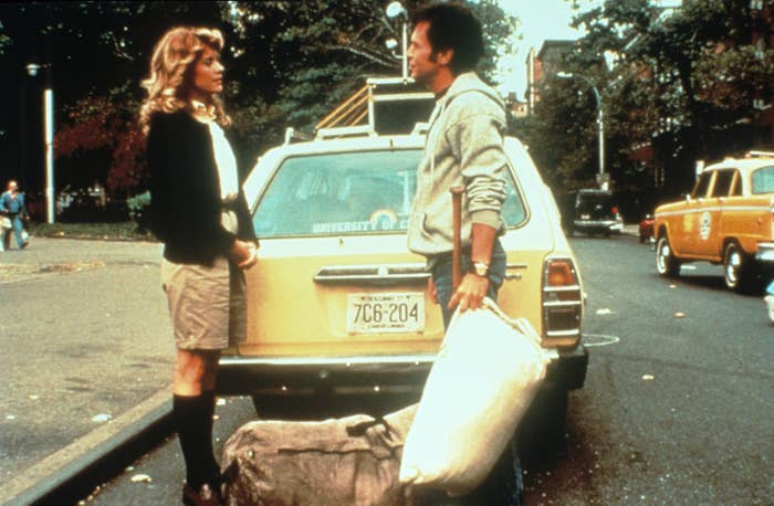 Meg Ryan and Billy Crystal standing behind a car.