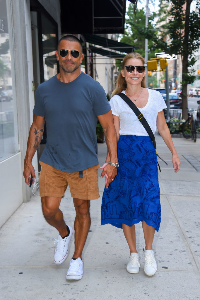the couple holding hands and walking down the street