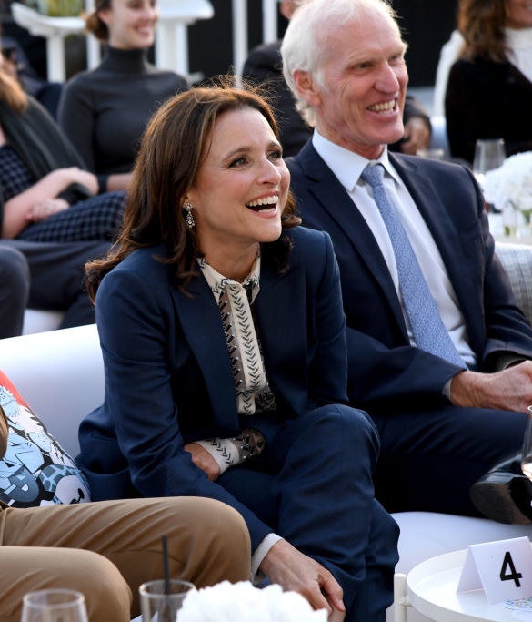 the couple laughing and sitting next to each other at an event