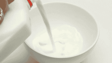 Milk being poured into a bowl
