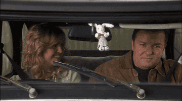 Ricky Gervais and Ashley Jensen making goofy faces at each other in a scene from Extras