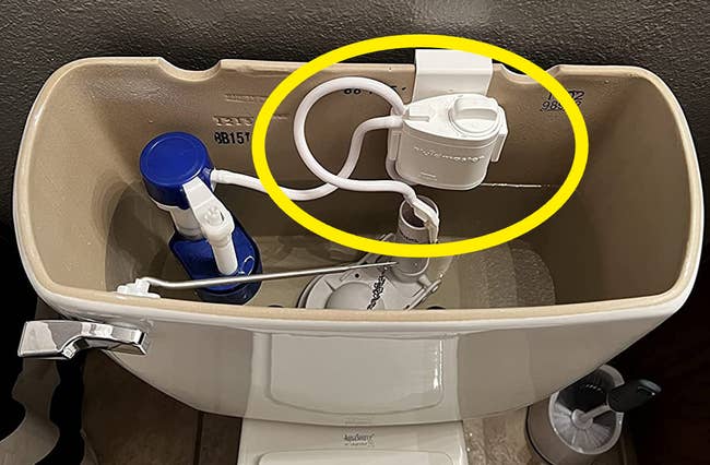 A reviewer's Fluidmaster circled in yellow installed in the fill valve of a toilet