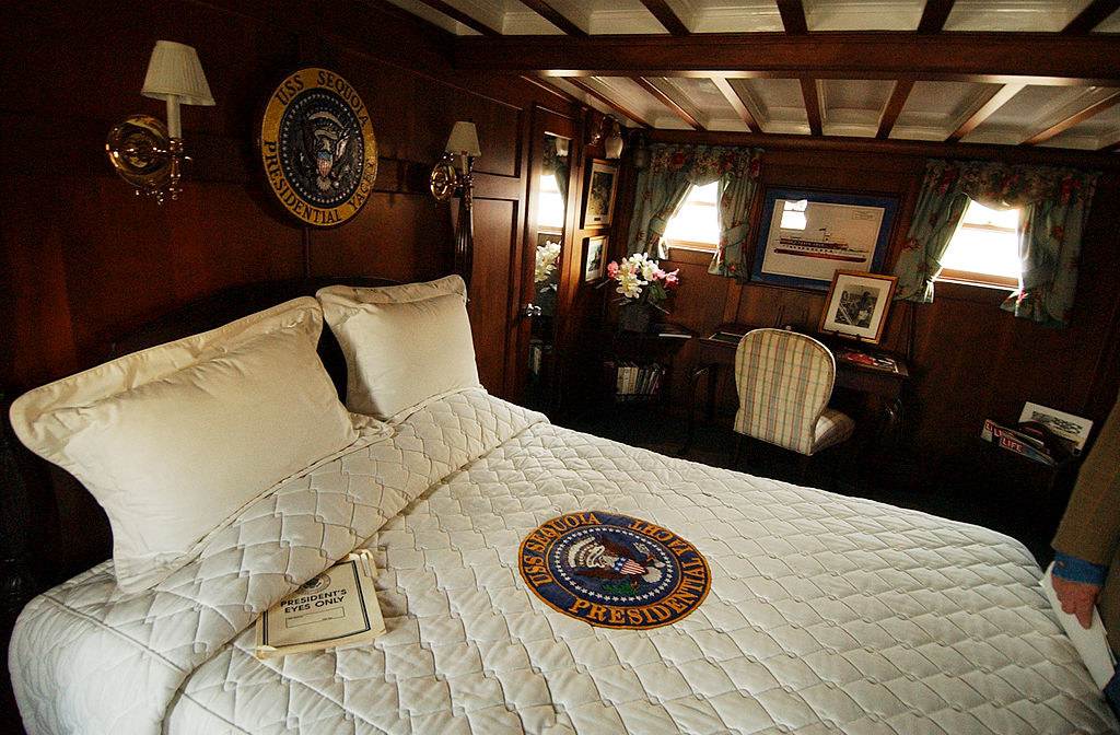 A large bed with the seal &quot;USS Sequoia presidential yacht&quot; on the comforter