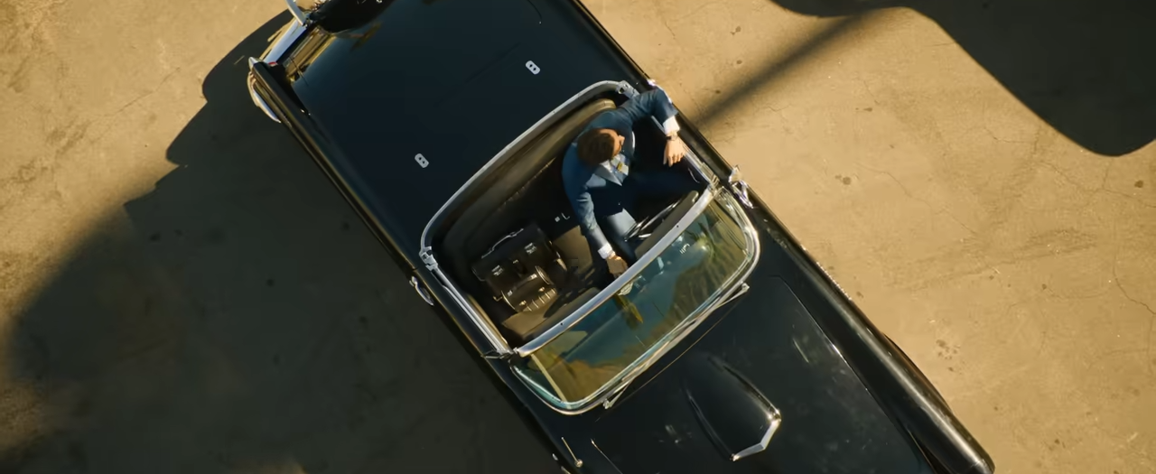 An overhead view of a man sitting in his vintage car