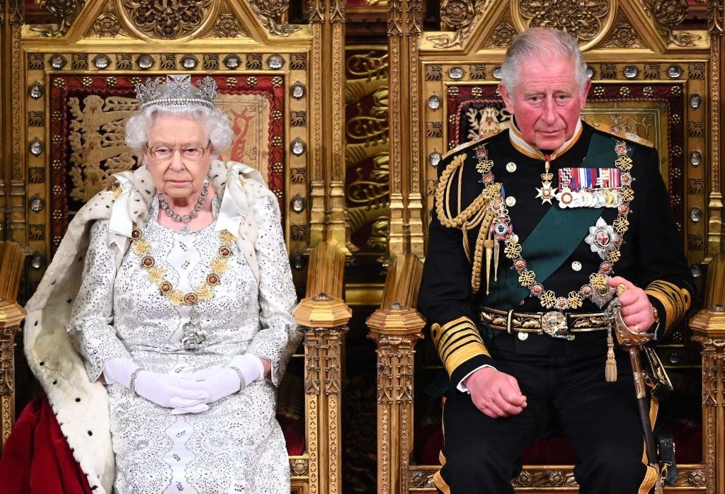 Queen Elizabeth II and Prince Charles both sitting on royal thrones