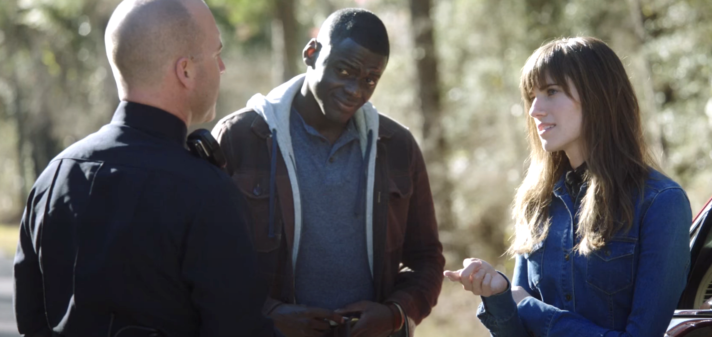 Man and woman speak to a police officer