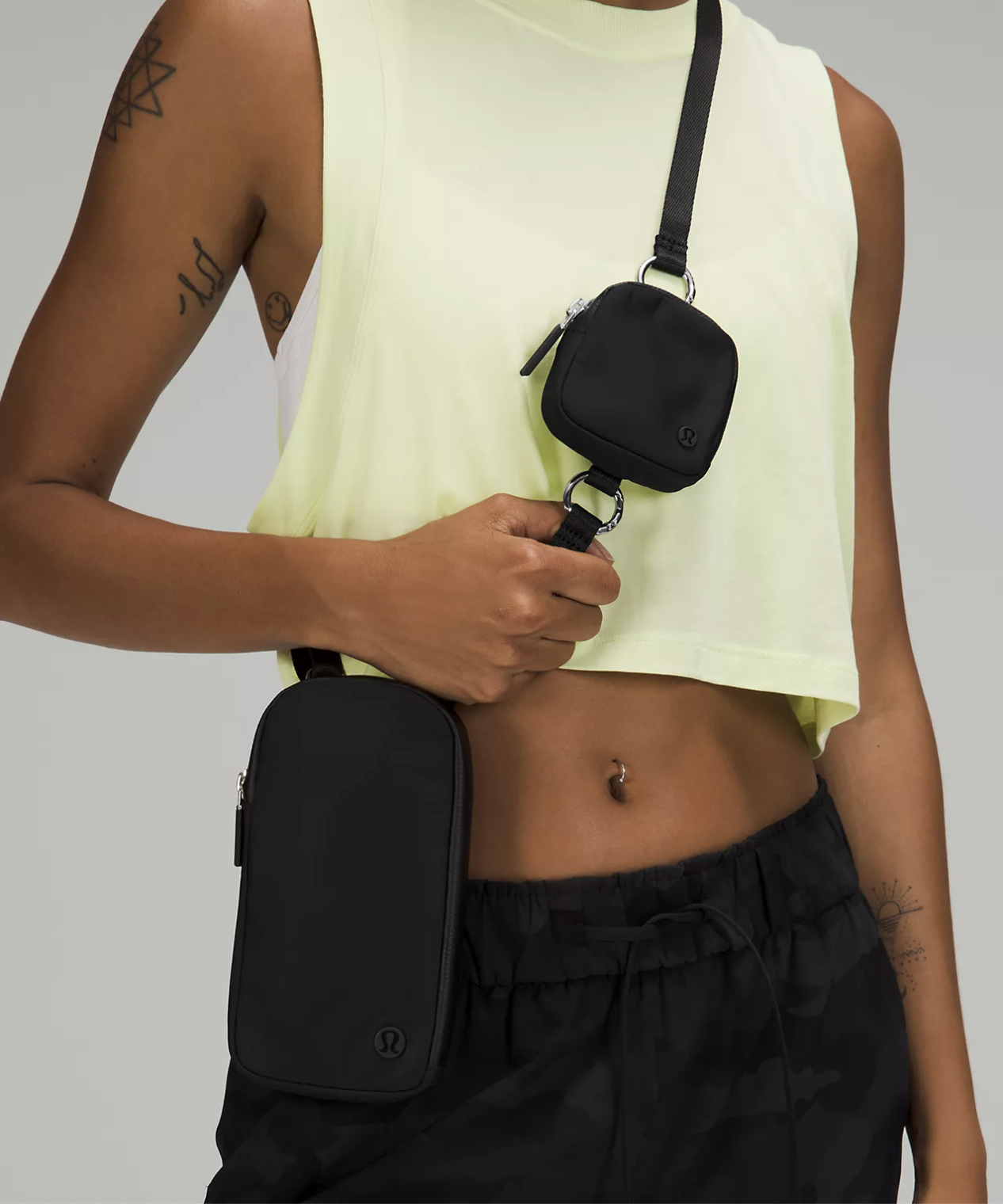 A person wearing the crossbody bag with joggers and a crop top