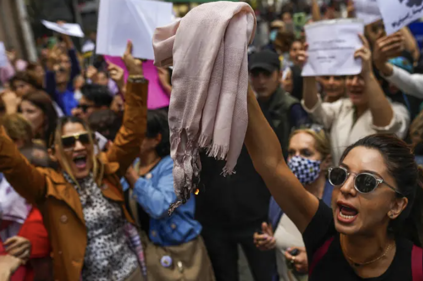 crowd of protesters raising up headscarves