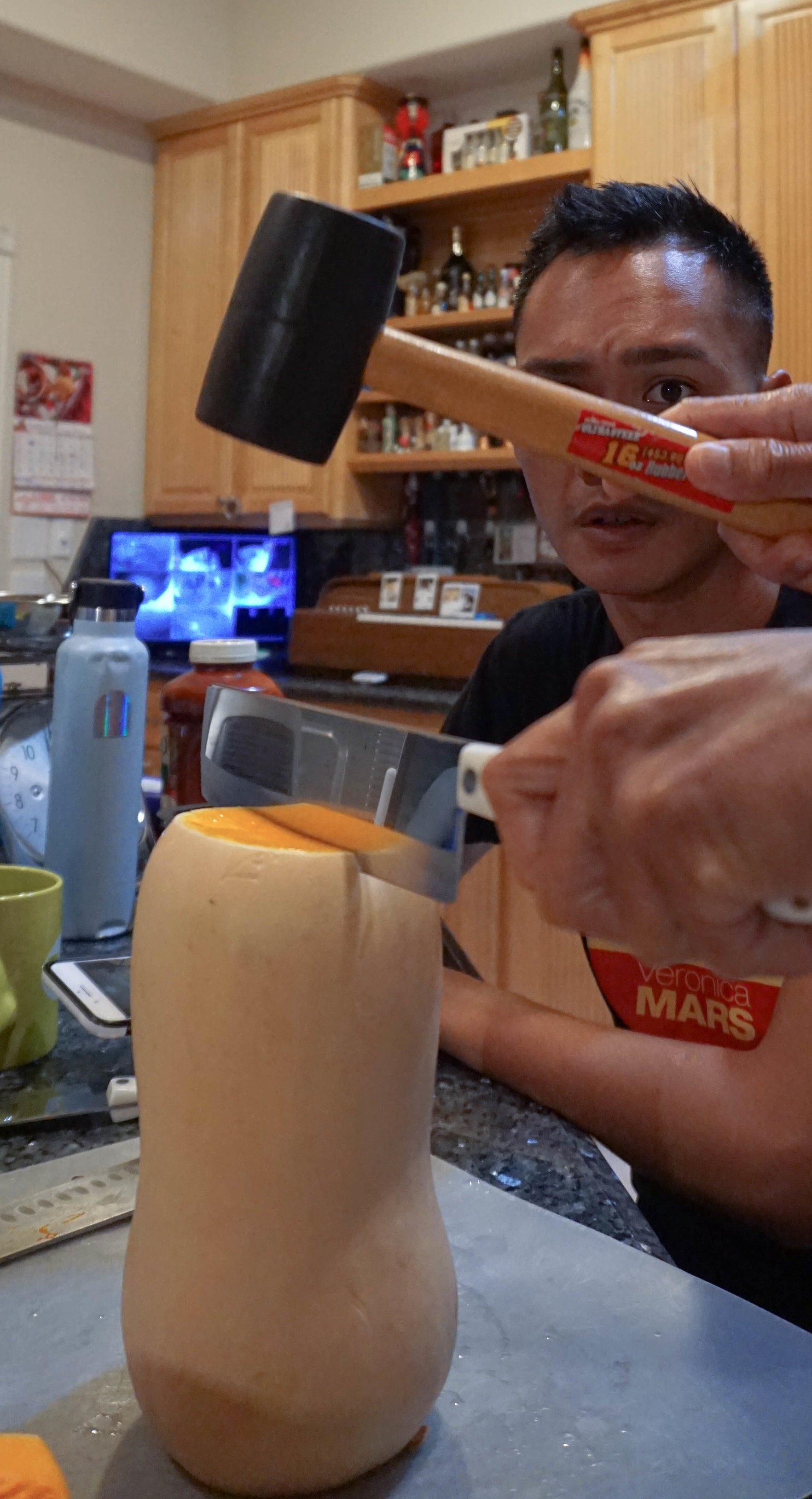 author looking at a rubber hammer being used to assist a knife in cutting through a butternut squash