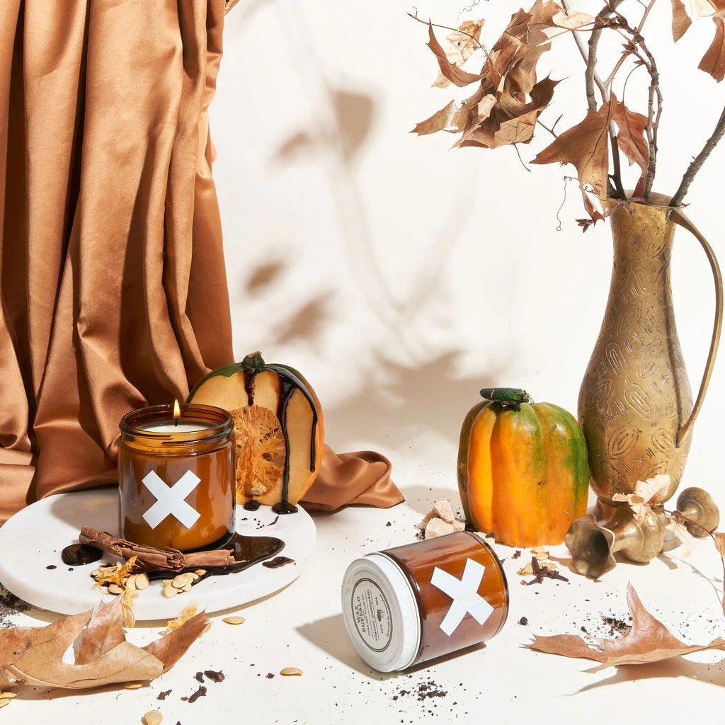 pumpkin-scented fall candles next to autumn-themed table setting