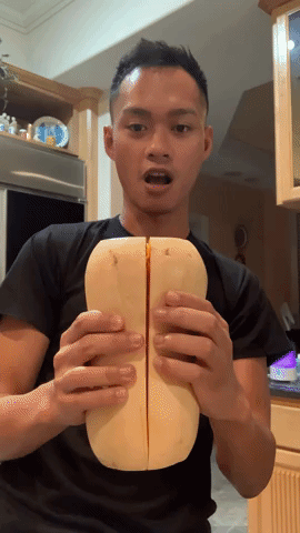 author opening up a halved butternut squash