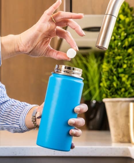 a person putting a tab into a thermos