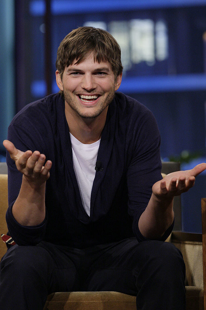 Kutcher with his hands up in the air