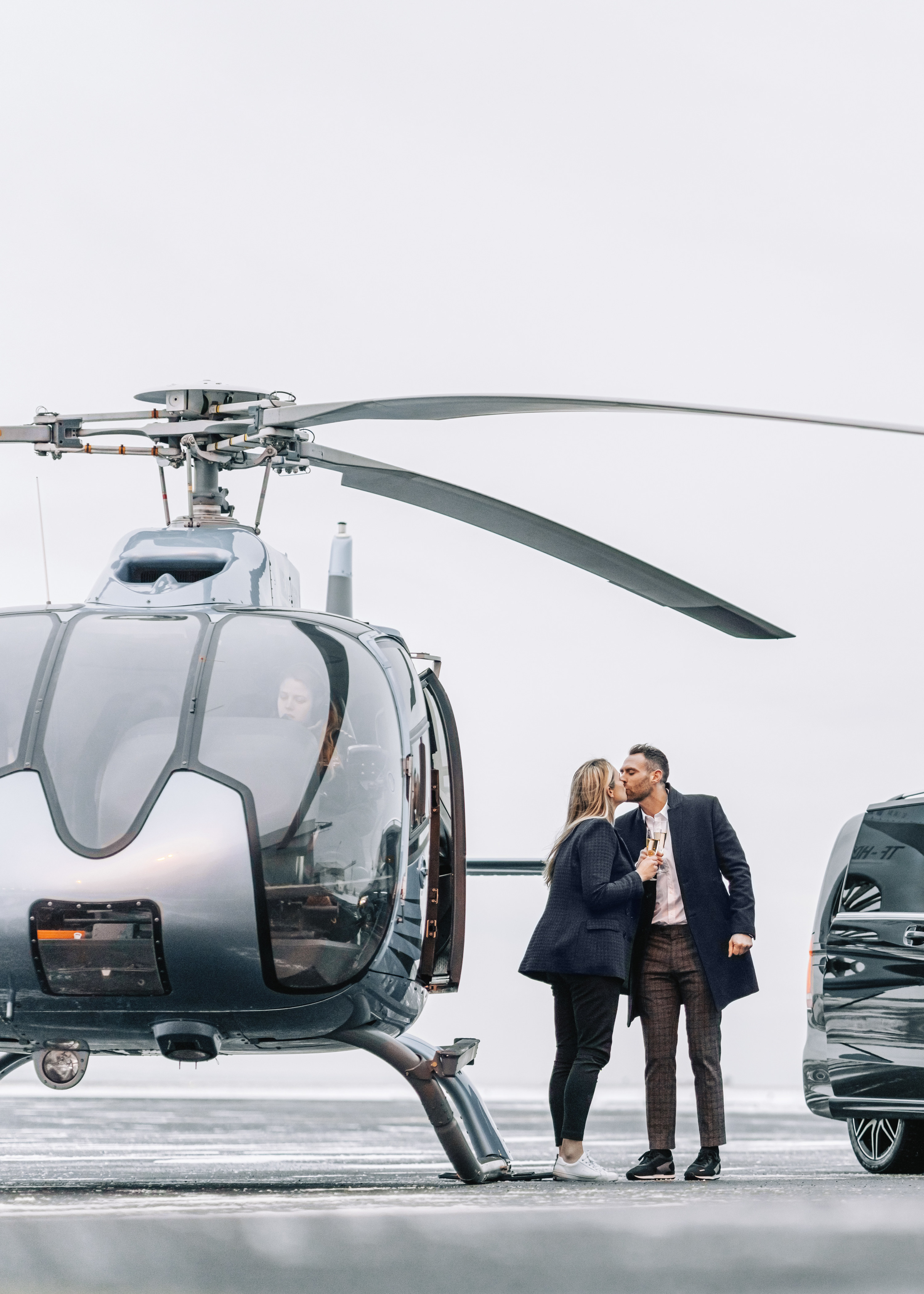 rich guy kissing his partner before getting in his helicoptor