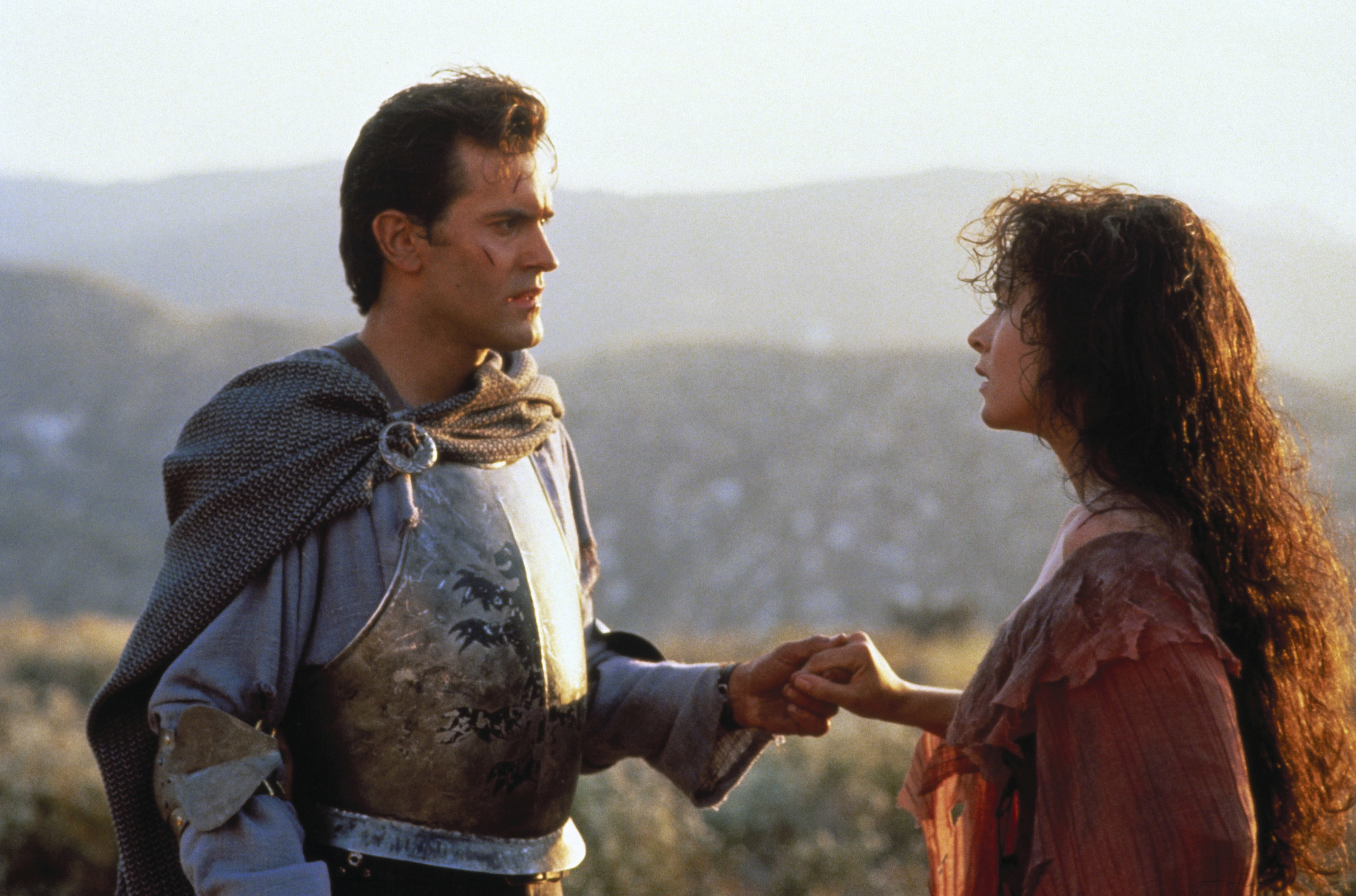 Bruce Campbell and Embeth Davidtz holding hands.