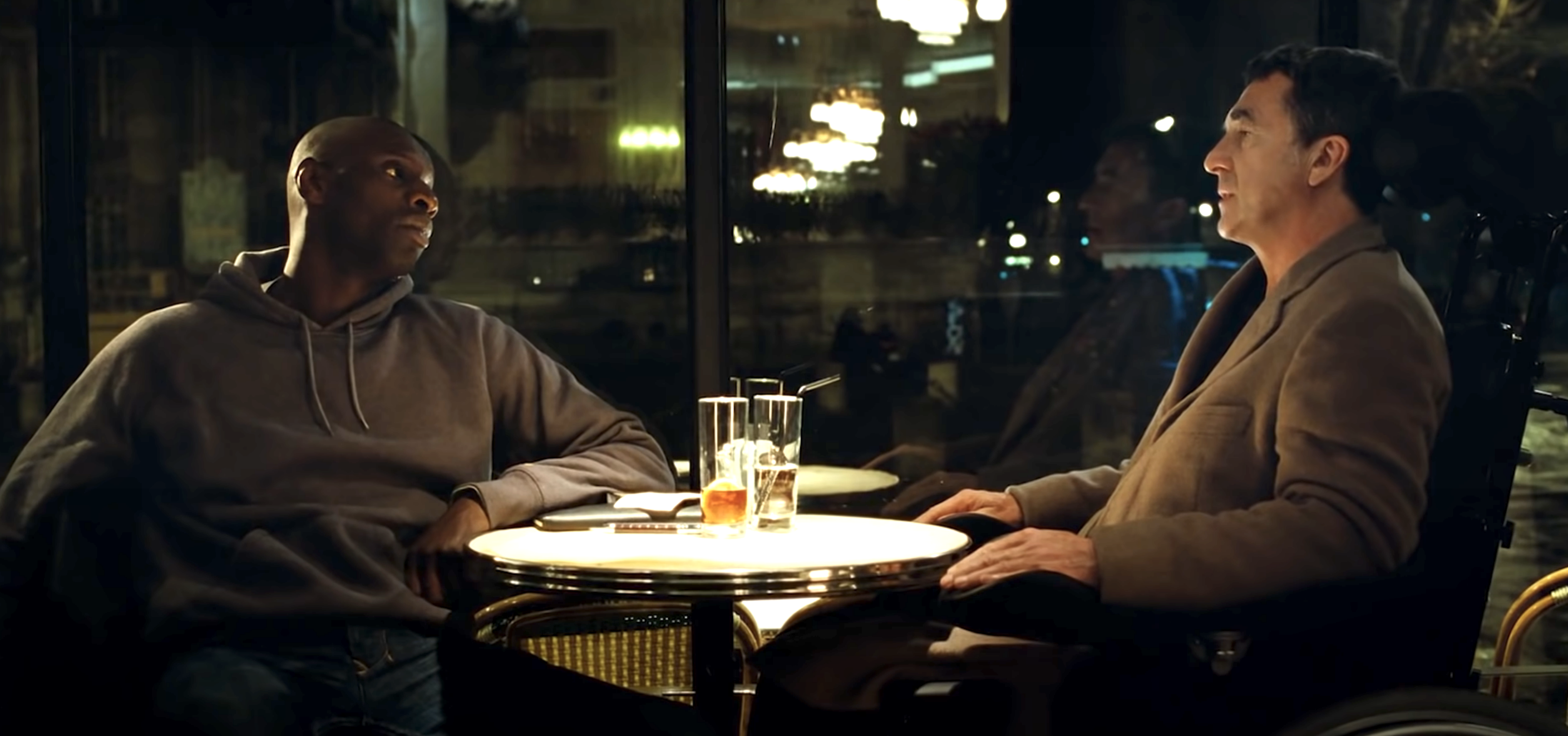 A man on a wheelchair sit at dinner table with another man